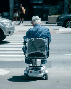 Anciano con scooter en paso de cebra