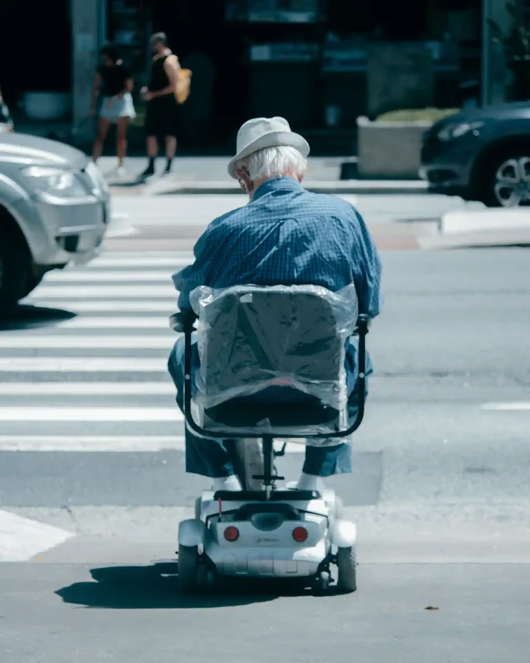 Anciano con scooter en paso de cebra